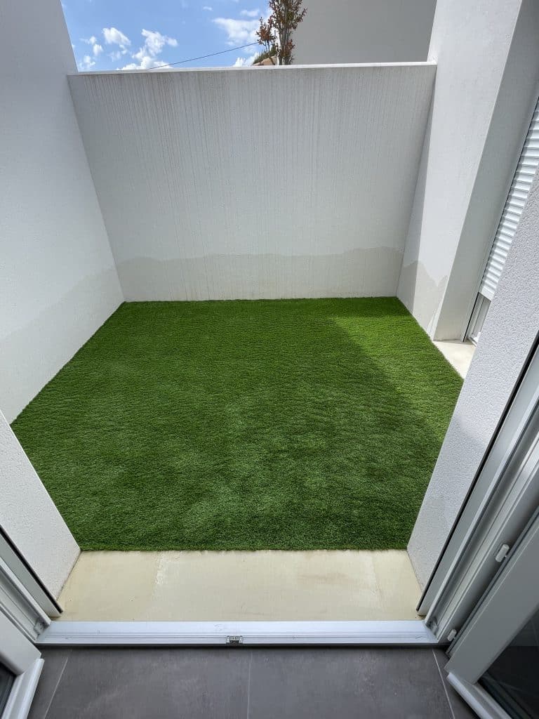 Pose de gazon synthétique sur une terrasse couverte, solution esthétique et sans entretien pour espace extérieur réduit.