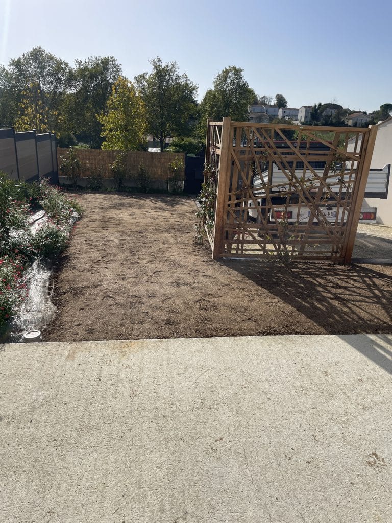 Terrain préparé pour création de jardin, surface nivelée avec structure bois en cours d’installation.