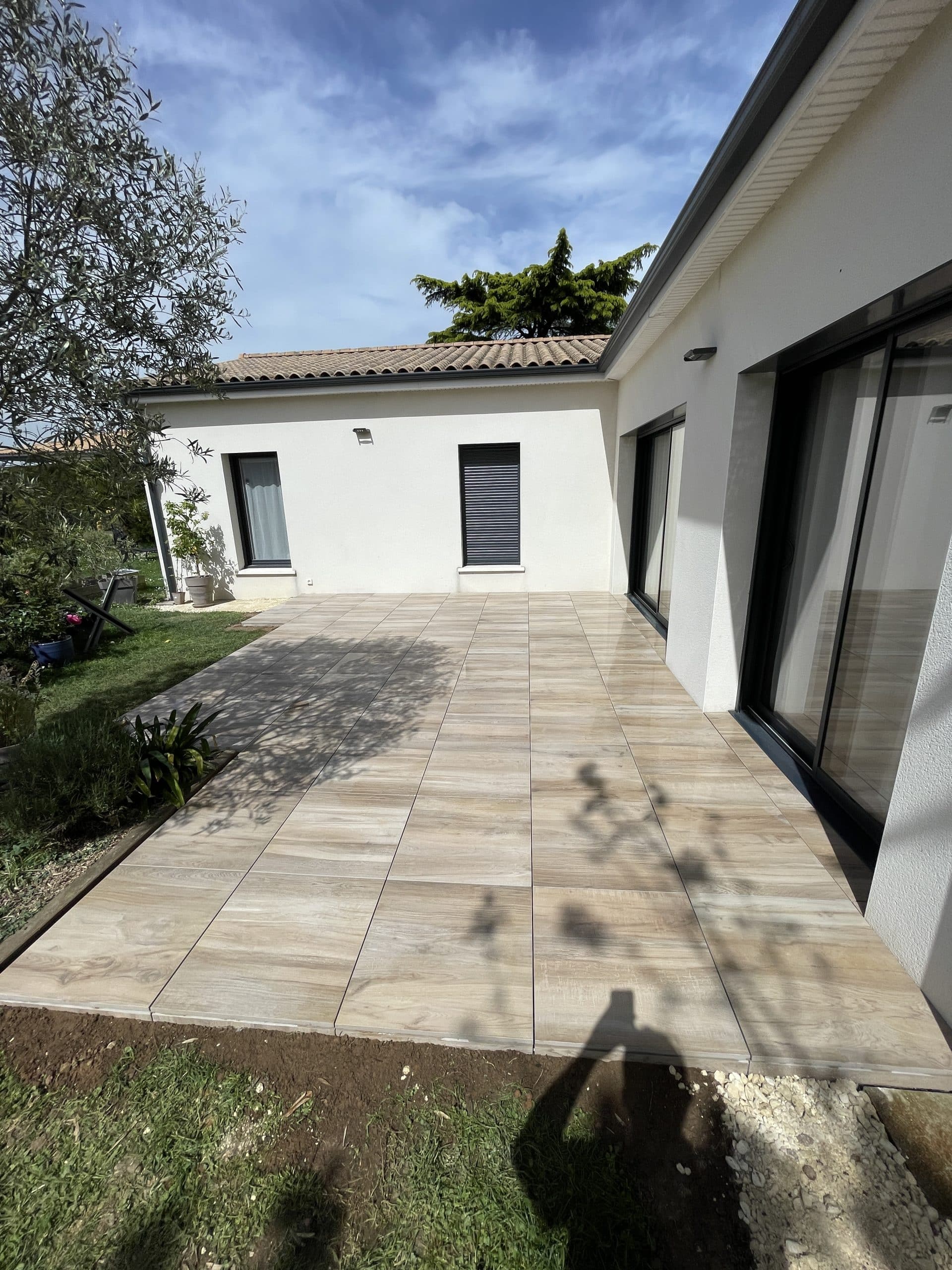 Terrasse en dalles effet bois aménagée devant une maison contemporaine, création d’un espace extérieur esthétique et fonctionnel.